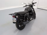 a black motorcycle parked in a room with a white wall