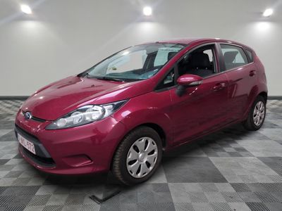 une Ford Fiesta rouge garée sur un sol en carrelage à damier