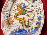 une assiette ornée d'un dragon, posée sur une nappe rouge