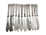 six silver spoons are lined up in a row on a white surface