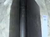 a black book with gold writing on it on a bed
