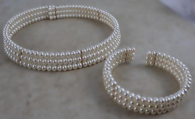 deux bracelets en perles et une bague posés sur une surface en marbre