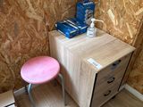 un petit bureau avec un tabouret rose dans un coin de la pièce