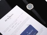 a watch sitting on top of a box next to a credit card