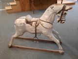 a wooden rocking horse that is on display in a room
