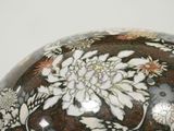 a black and white vase with a flower design on it