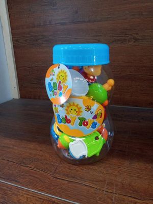 a plastic jar filled with lots of toys on a table