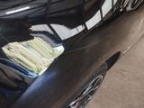 a black car parked in a garage with a lot of money in it