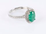 a close up view of a green emerald and diamond ring