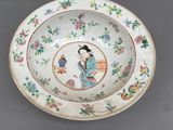 an image of a plate with a woman holding a fan on it