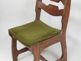 a wooden chair with a green cushion on it