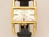 an image of a gold watch with a black strap