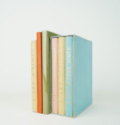 trois livres sont empilés sur une surface blanche