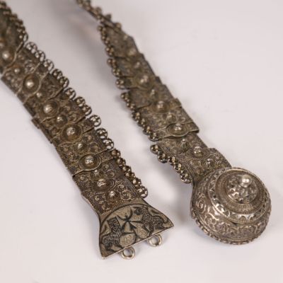pair of antique silver bracelets on a white surface with a white background