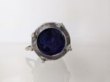 a close up of a ring with a blue stone in it