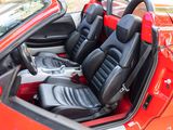 the interior of a red sports car with black seats and a steering wheel