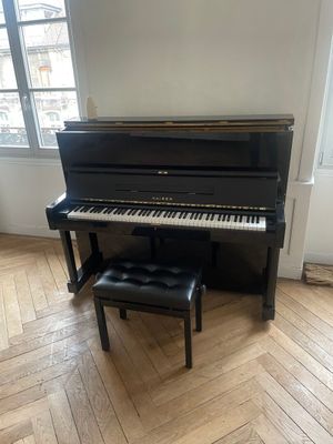 a piano in the corner of a room with a bench