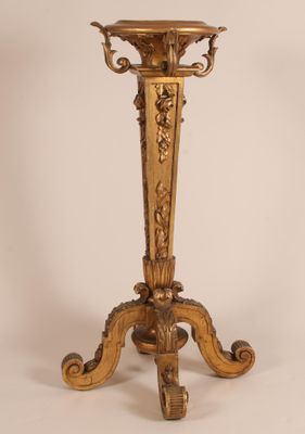 un vase doré posé sur un socle, sur fond blanc