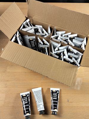 trois tubes de dentifrice dans une boîte en carton posée sur une table