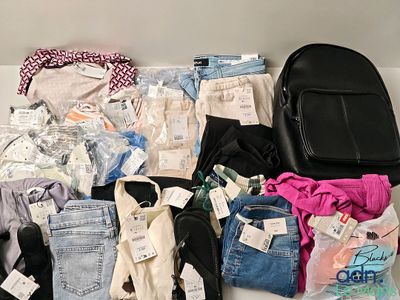 beaucoup de vêtements et un sac à dos posés sur une table