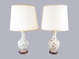 deux lampes blanches ornées d'un motif floral, placées l'une à côté de l'autre