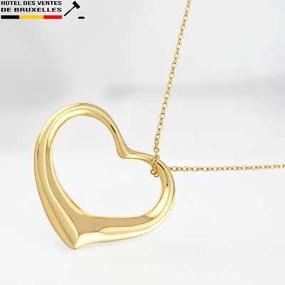 un pendentif en forme de cœur en or avec une chaîne, sur fond blanc