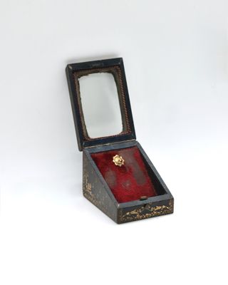 a small wooden box with a ring inside of it