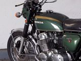a green motorcycle parked in a garage with a white wall behind it
