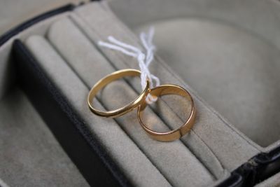 two gold wedding rings sitting on top of a ring case