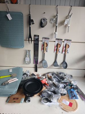 many kitchen utensils hanging on the wall above the counter