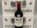 une bouteille de vin posée à côté de deux cartons de vin