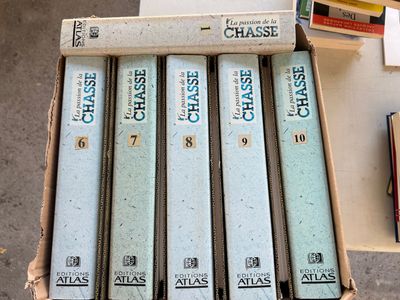 plusieurs livres sont empilés dans une boîte