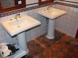 deux lavabos dans une salle de bains dont les murs et le sol sont carrelés