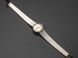 une montre-bracelet argentée avec un cadran blanc et un bracelet argenté