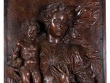 un relief en bois représentant une femme tenant un enfant sur ses genoux
