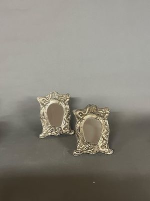 deux cadres photo en argent avec un miroir, posés sur une table