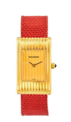 une photo d'une montre dorée et rouge avec un bracelet rouge
