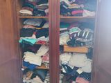 une armoire pleine de vêtements dans une pièce dont la porte est ouverte