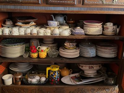 de nombreuses assiettes et tasses sur une étagère dans la cuisine