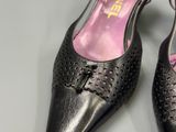 pair of women ' s black leather shoes with a bow on the heel