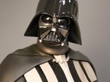 star wars action figure of dart vader holding a red light saber