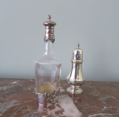 a bottle and a salt shaker sitting on a table