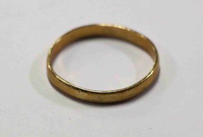 une image d'un gros plan d'une bague en or sur une surface blanche