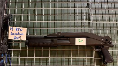 une arme exposée dans une vitrine grillagée