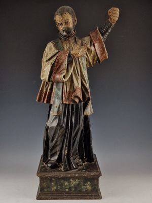 une vieille statue représentant un homme tenant une épée et vêtu d'une robe