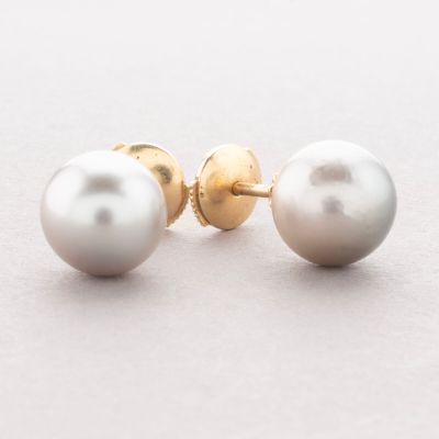 pair of pearl and gold stud earrings on a white surface