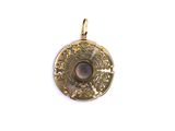 a close up of a gold pendant with a stone in the center