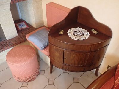 une petite table avec une chaise et un pouf dans une pièce