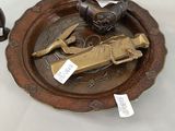a plate with a statue on it next to a cup and saucer