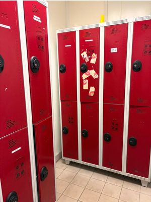 Plusieurs casiers rouges sont alignés en rang dans une pièce